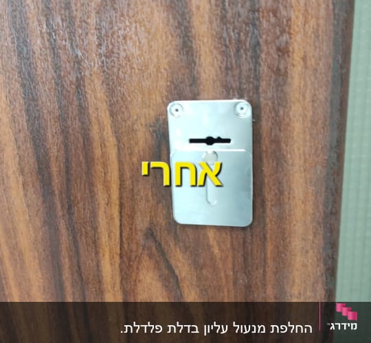 מנעול מתכת על דלת עץ עם ברגים